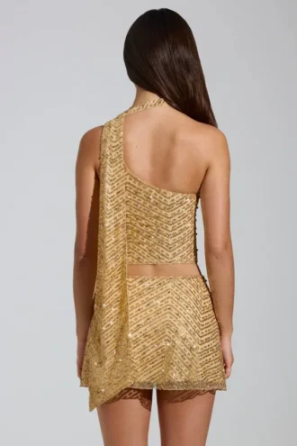 Cosette-top med asymmetrisk scarf-detalj i guld