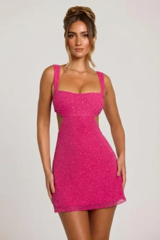 Emilion miniklänning med utskärningar och dekorationer i fuchsia