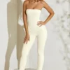Jamila axelbandslös jumpsuit med utsvängd fåll i elfenben
