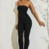 Jamila axelbandslös jumpsuit med utsvängd fåll i svart