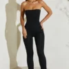 Jamila axelbandslös jumpsuit med utsvängd fåll i svart