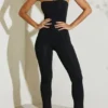 Jamila axelbandslös jumpsuit med utsvängd fåll i svart
