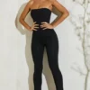 Jamila axelbandslös jumpsuit med utsvängd fåll i svart