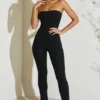 Jamila axelbandslös jumpsuit med utsvängd fåll i svart