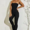 Jamila axelbandslös jumpsuit med utsvängd fåll i svart