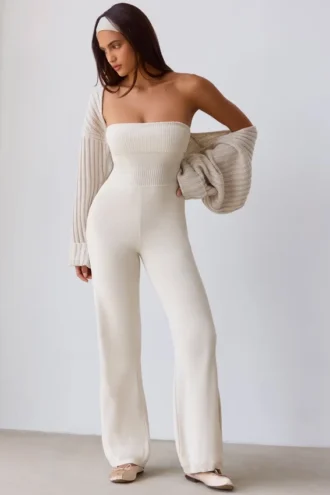 Jumpsuit i grovstickat tyg med bandeau-halsringning och utsvängda byxben i krämfärg