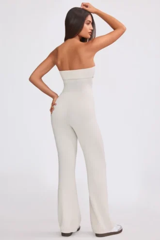 Jumpsuit i grovstickat tyg med bandeau-halsringning och utsvängda byxben i krämfärg