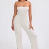 Jumpsuit i grovstickat tyg med bandeau-halsringning och utsvängda byxben i krämfärg