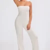 Jumpsuit i grovstickat tyg med bandeau-halsringning och utsvängda byxben i krämfärg
