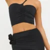 Tesia Slinky Jersey asymmetrisk topp med rosdetaljer i svart